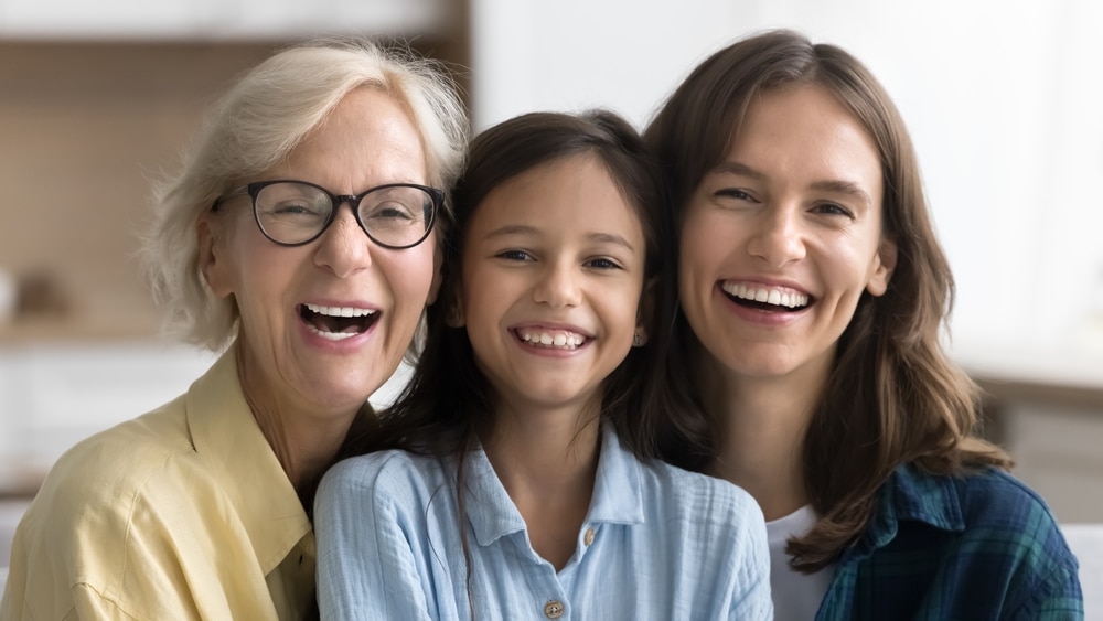 Grandmother, mother and daughter smiling together